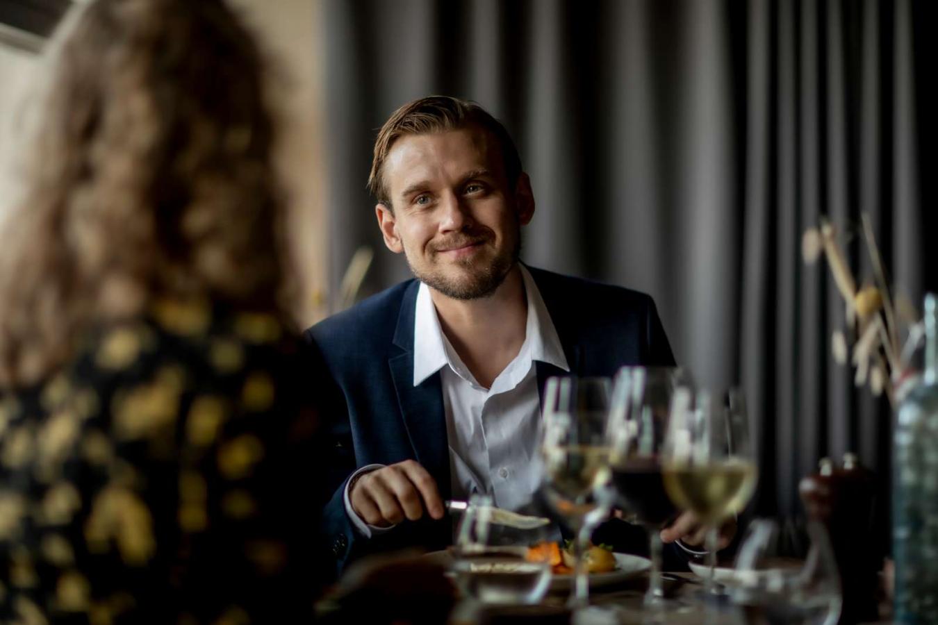 Mand i jakkesæt spiser på restaurant