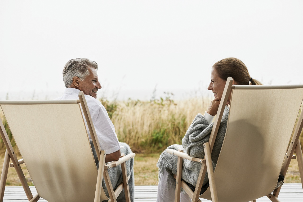 Par hygger sig i strandstole ved vandet