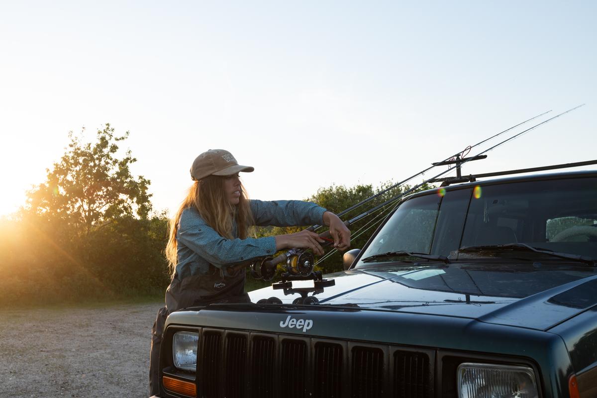 Kvinde står ved bil og fiskestand