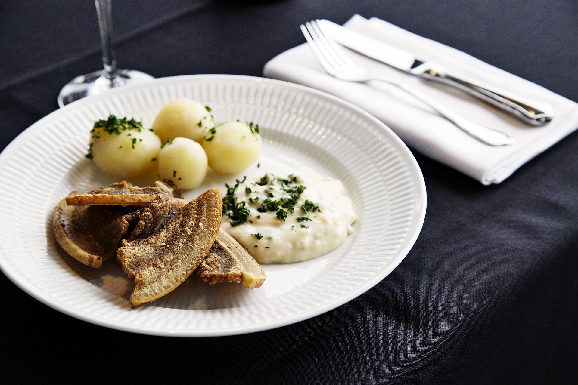 Servering med stegt flæsk med persillesovs