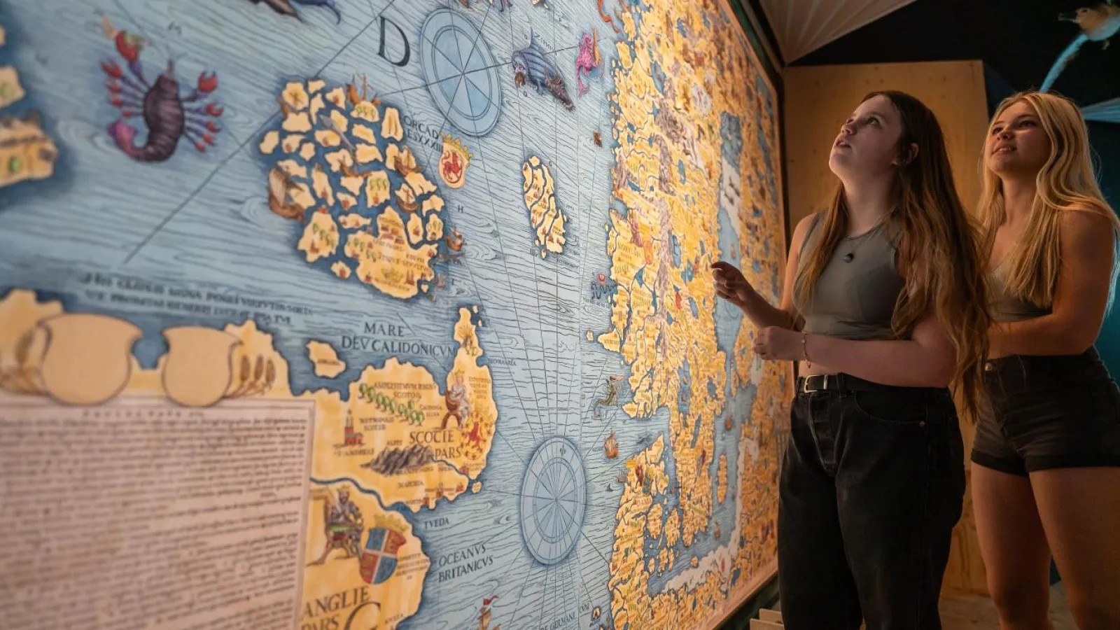 To unge kigger på et stort historisk kort på museum