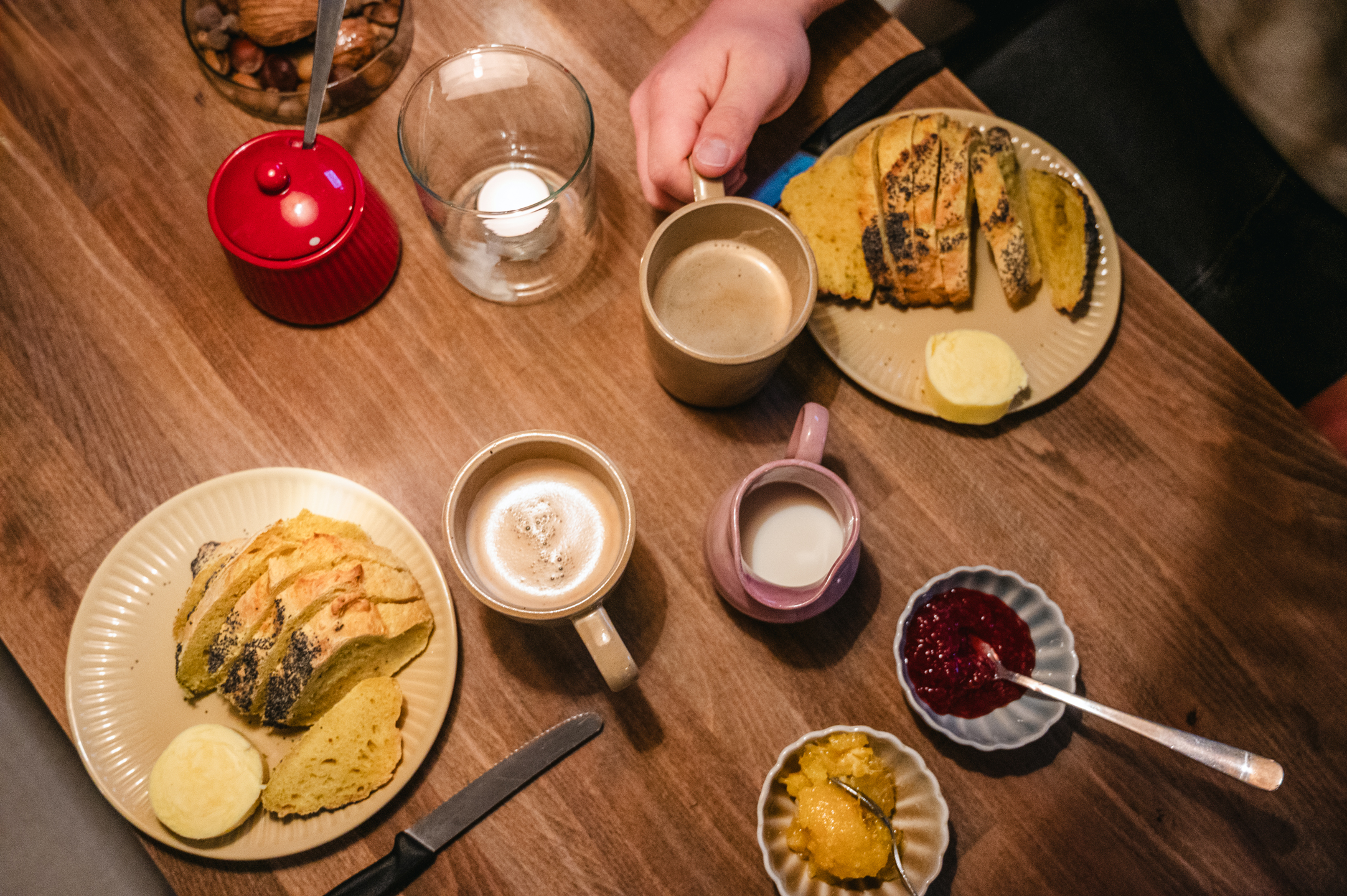 Bord med kaffe, brød og små serveringer, set ovenfra