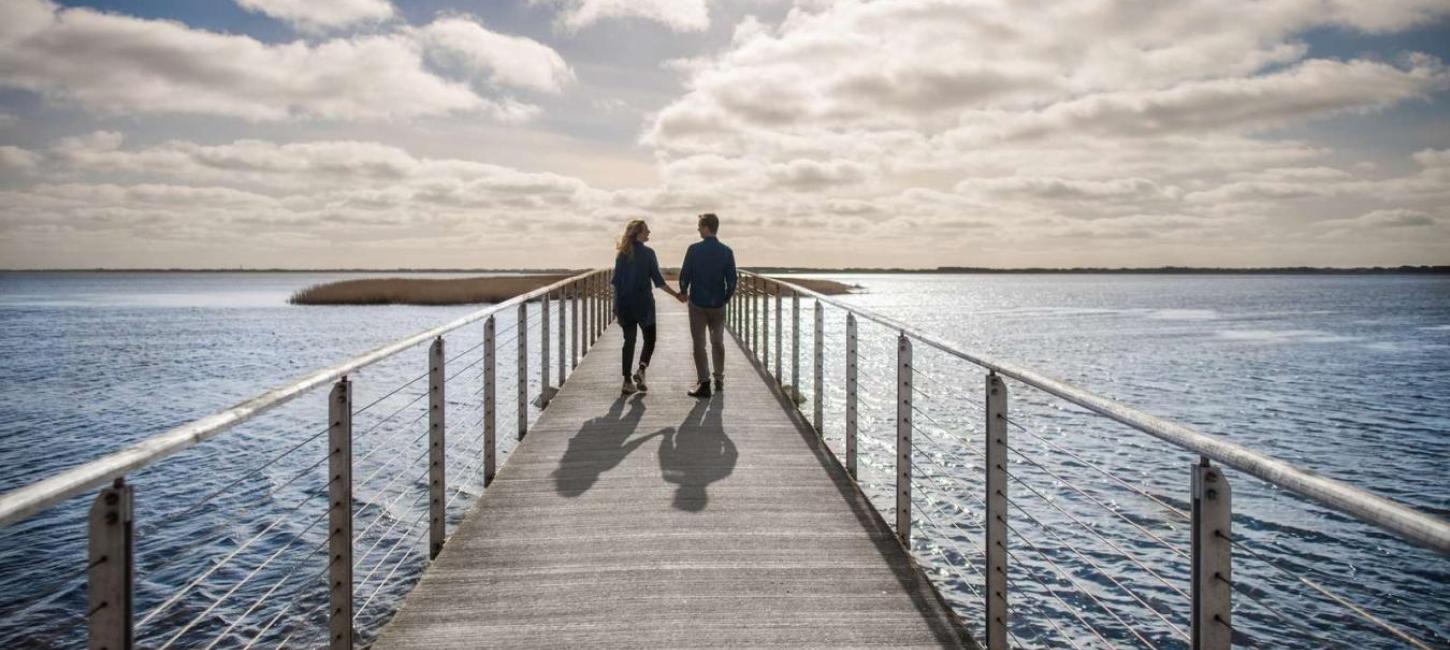 Couple walking on bridge at visitvesterhavet the North Sea 