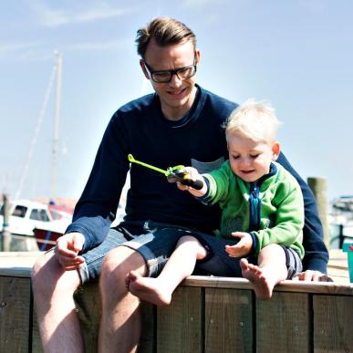 Far og søn sidder på kajen i Bork Havn