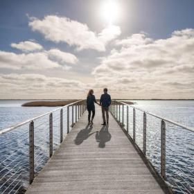 Couple walking on bridge at visitvesterhavet the North Sea 